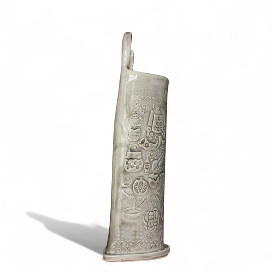 Side view of a Shana Tova stoneware vase with impressed apples, pomegranates, and Jewish holiday symbols.