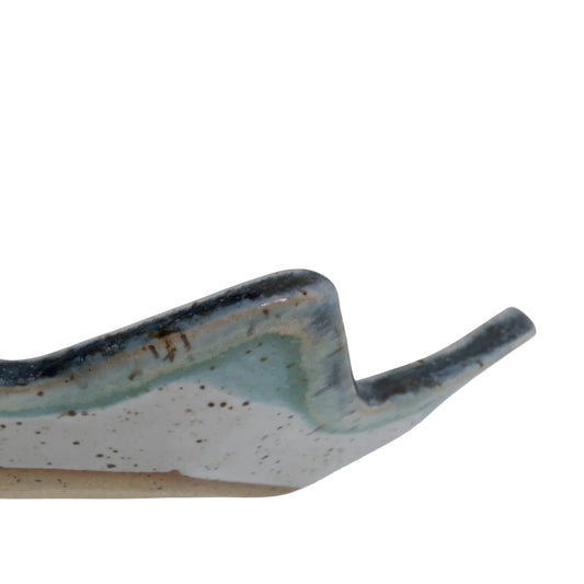 Side detail of the Star of David dish showing its raised pointed rim, blue-green glaze, and speckled clay.