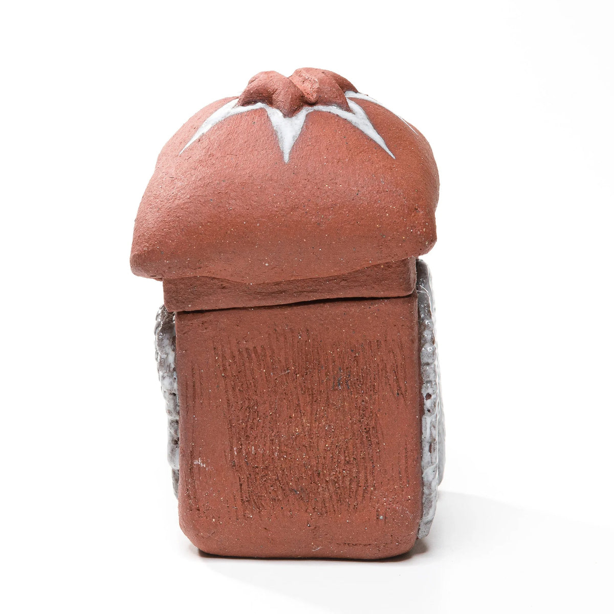 Straight-on view of the reddish-brown matchbox's textured side beneath a domed lid with a raised star and white accents