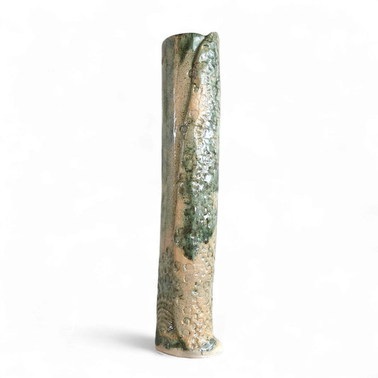 Tall, slender stoneware bud vase with mottled green and tan glaze, textured surface and an uneven rim