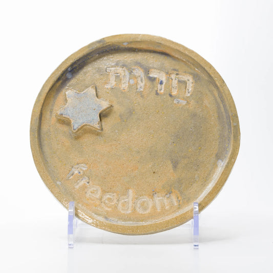 Golden-toned ceramic plate with Freedom lettering in English and Hebrew and a raised Star of David.