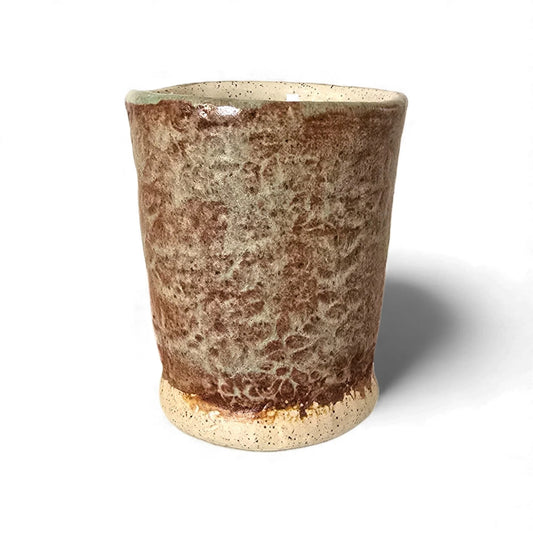 Handcrafted stoneware tumbler with mottled brown and cream glaze, a speckled cream interior, and an unglazed base.