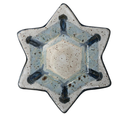 6-pointed Star-shaped ceramic dish with speckled white and pale blue glaze, dark blue accents, and a dark rim.