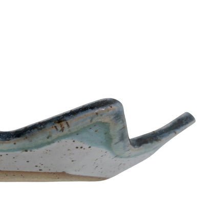 Side detail of the Star of David dish showing its raised pointed rim, blue-green glaze, and speckled clay.