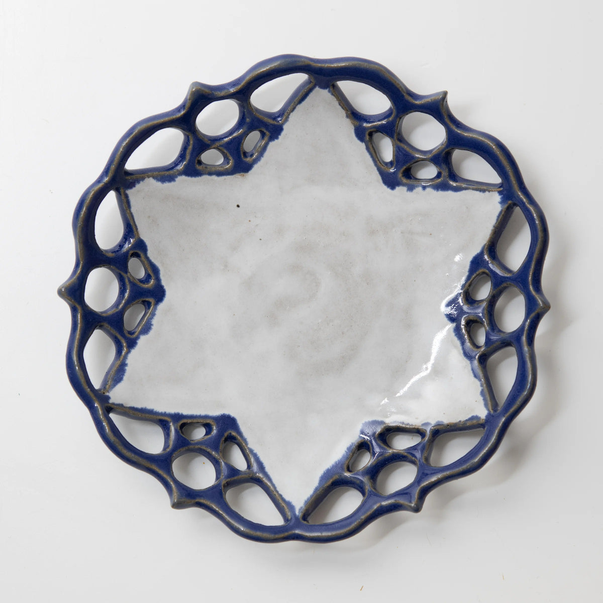 Ceramic plate with a white Star of David center surrounded by a cobalt blue openwork lace rim